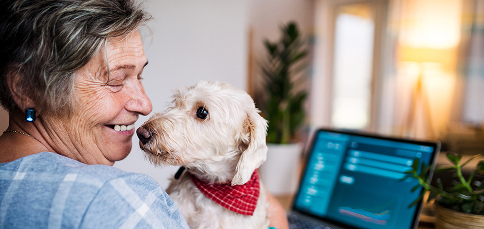 lady sitting at her desk, holding and staring at her dog